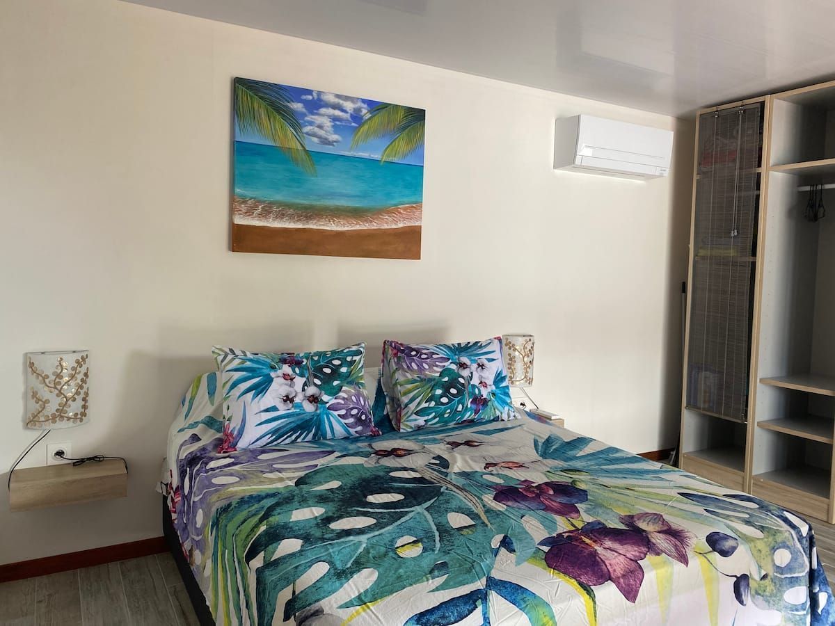 Chambre de Reva avec lit queen size et climatisation